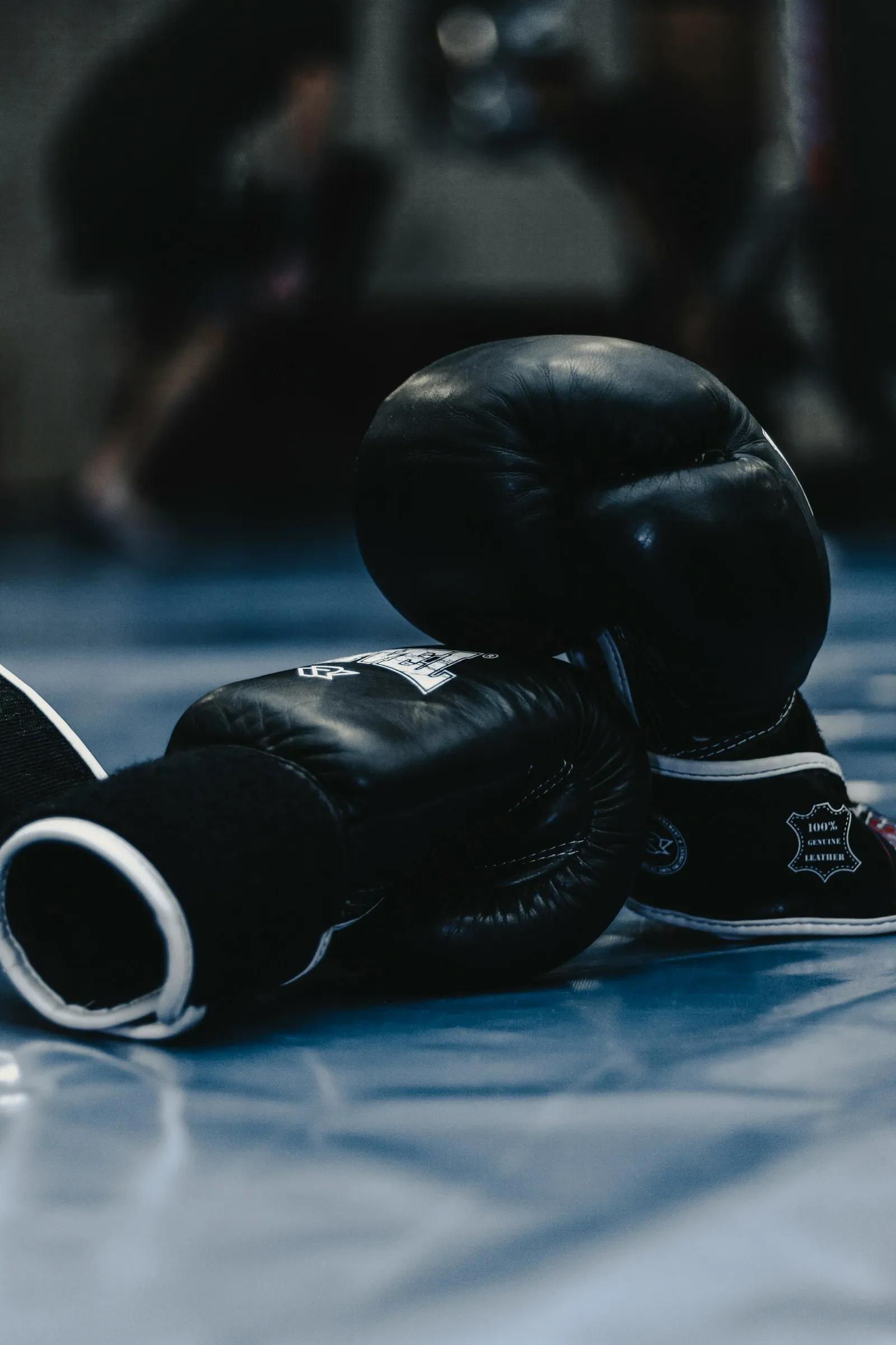 A pair of black boxing gloves on a mat
