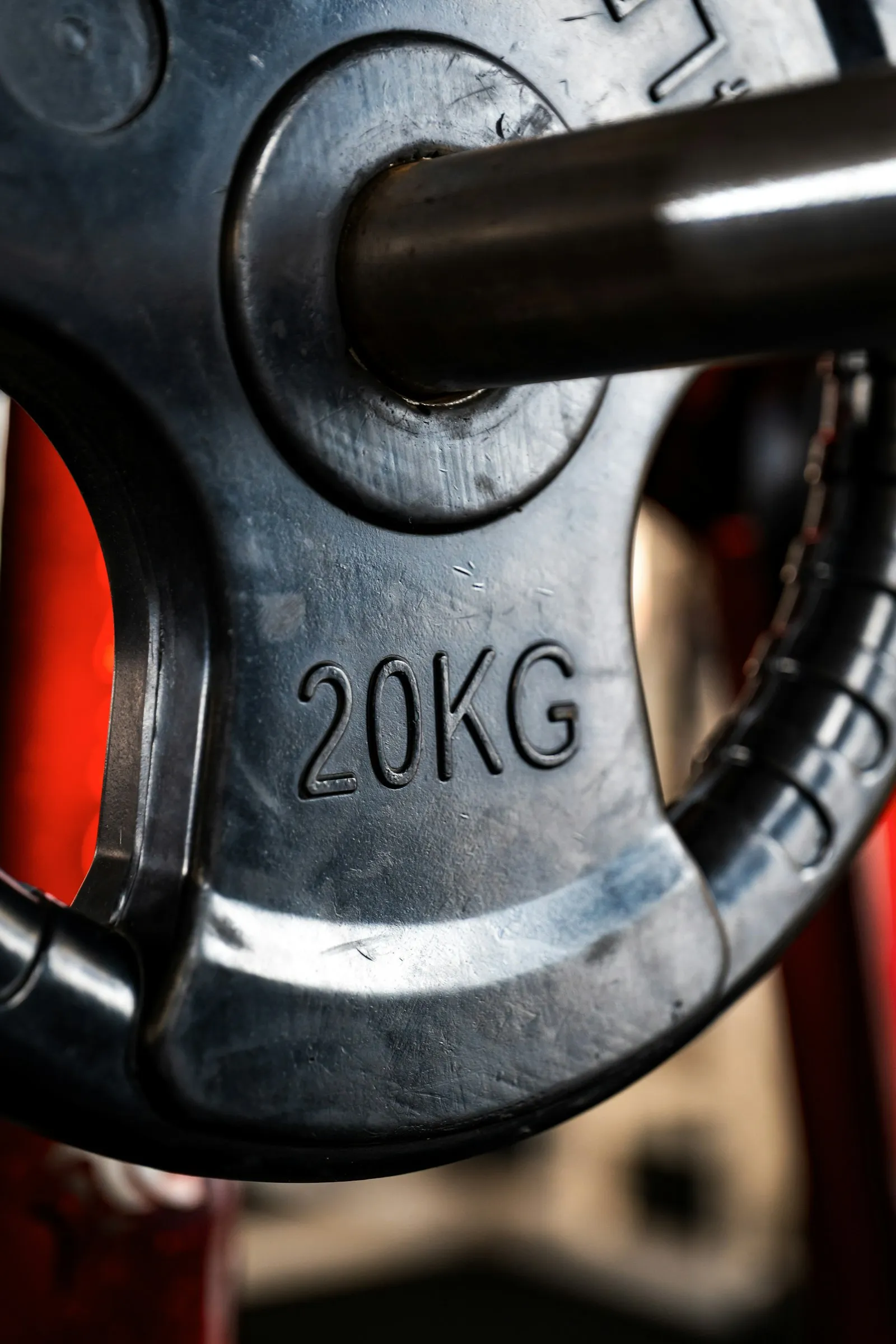 A black 20 kg plate on a barbell